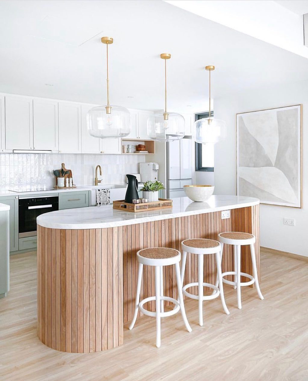 White kitchen with round kitchen island and wood paneled